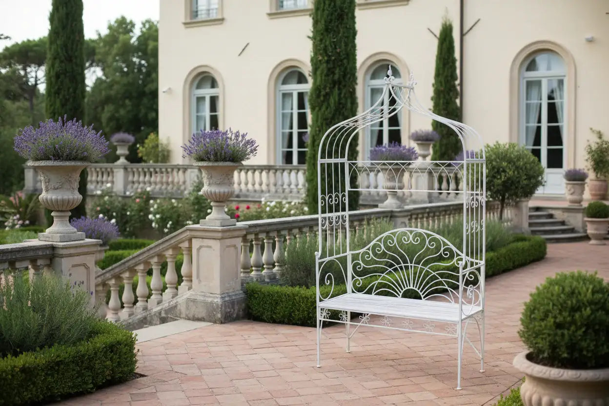 Decorative white metal bench in a garden setting with a mansion in the background