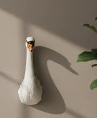 White swan-shaped lamp on a dark wooden surface