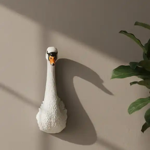 White swan-shaped lamp on a dark wooden surface