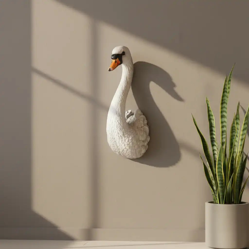 Decorative swan wall sculpture on a beige wall with a potted plant below.