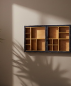 Wooden display case with glass doors on a beige wall