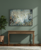 Wooden console table with a potted plant and abstract painting on a green wall