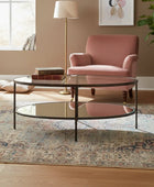 Living room with a pink armchair, glass coffee table, and decorative elements.