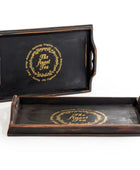 Two black trays with gold text on a white background