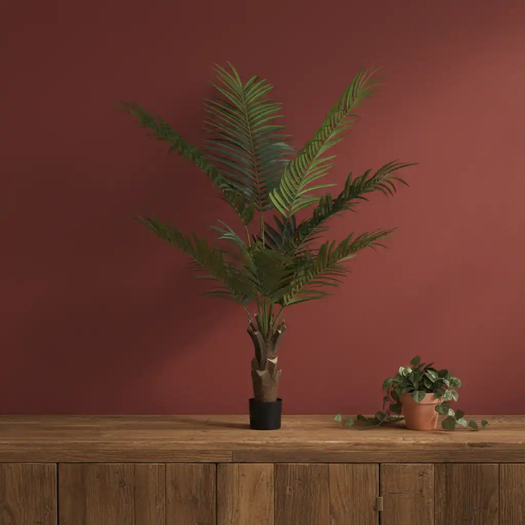 Potted plant on a wooden surface with a red-brown wall background