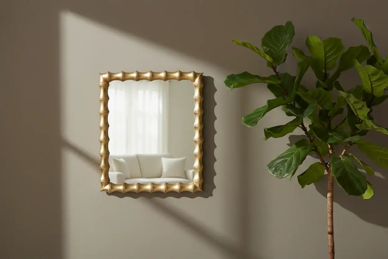Decorative mirror with a gold frame on a wall next to a potted plant