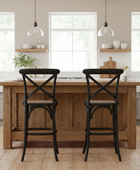 Wooden kitchen island with two black bar stools in a bright kitchen setting.