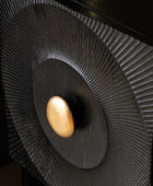 Close-up of a speaker with a gold ball in the center