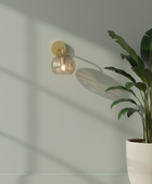 Wall-mounted light fixture with a plant on a neutral background