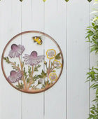 Decorative metal wall art with flowers and a bee on a white wooden background