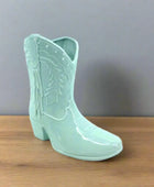 Mint green cowboy boot with detailed design on a white background