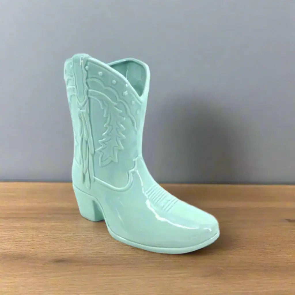 Mint green cowboy boot with detailed design on a white background