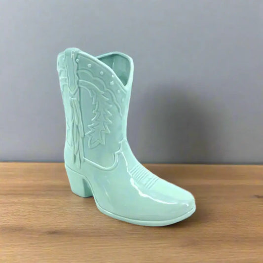 Mint green cowboy boot with detailed design on a white background