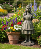 Statue of a girl in a garden with flowers and plants