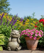 Cat-shaped garden ornament with flowers and plants in a garden setting