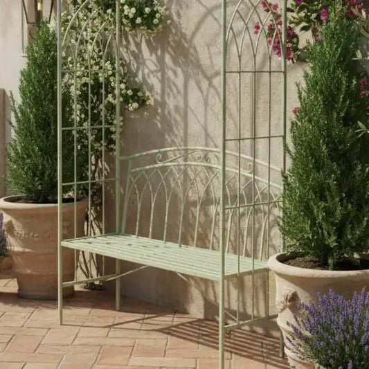 Decorative metal bench with floral arches and potted plants in a garden setting.