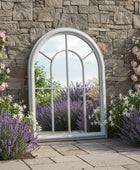 Decorative garden scene with stone wall, arched window, and flowers.