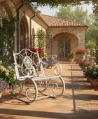 White metal rocking chair on a patio with flowers and a house in the background