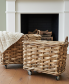 Two wicker baskets with wheels in front of a fireplace.