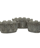 Set of four decorative metal planters with leaf pattern on a white background