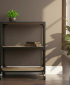 Bookshelf with wooden bottom shelf and metal frame in a room with plants and books.