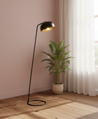 Modern floor lamp with a plant on a wooden floor in a room with pink walls and a window.