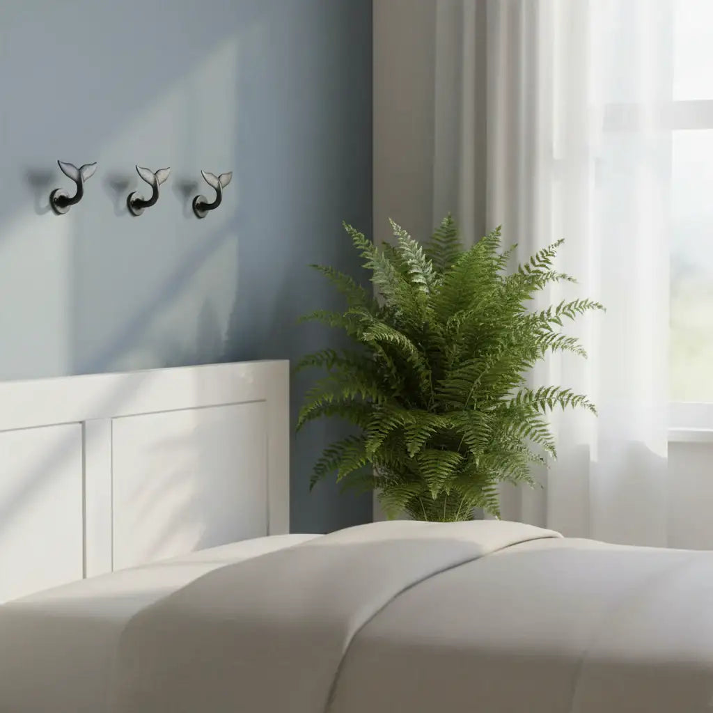 Modern bedroom with a bed, plant, and decorative wall hooks.