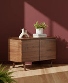 Wooden cabinet with decorative items against a maroon wall