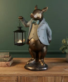 Decorative figurine of a rabbit in a suit holding a lantern on a wooden surface with a green wall background.