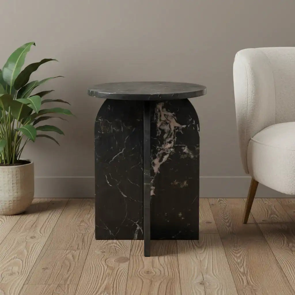 Black marble side table with a plant and chair in a room setting