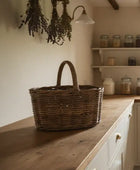 Wicker basket on a wooden countertop with shelves in the background