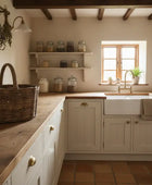 Narrow kitchen with wooden countertops, white cabinets, and a window.