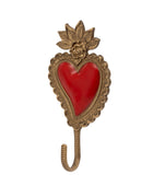 An ornate antique-style brass heart-shaped wall hook featuring a red enamel heart in the center, a sculpted face at the top, and a hanging hook below, shown on a plain white background.