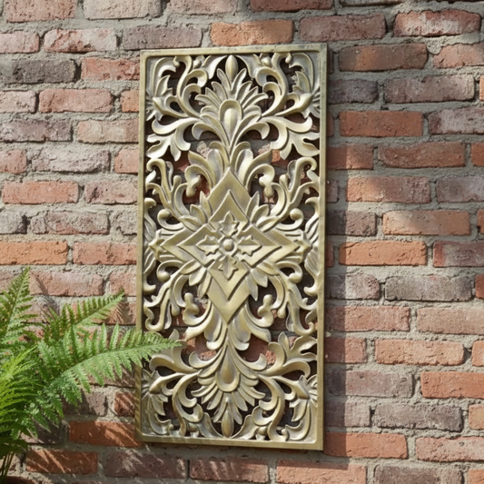 Decorative wall panel with intricate carvings on a brick wall
