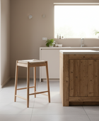 Wooden stool in a modern kitchen with a wooden island and neutral decor.
