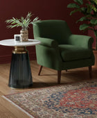 Round side table with marble top and ribbed black base on a white background