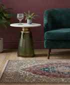 Small round table with a glass top, green ribbed base, and decorative items on a white background