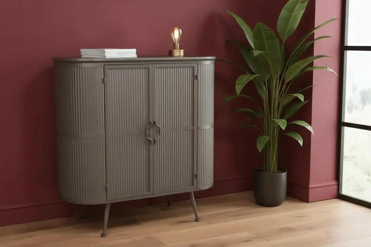 Gray cabinet with a plant and books against a red wall