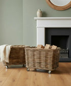 Wicker baskets on wheels in a room with a fireplace and mirror.