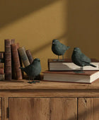 Decorative birds on books against a warm brown wall