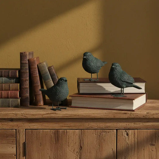 Decorative birds on books against a warm brown wall
