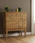 Wooden cabinet with multiple drawers against a brown wall.