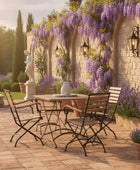 Outdoor patio set with table and chairs surrounded by lavender plants and a stone wall.