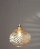 Decorative pendant light with textured glass shade on a dark background