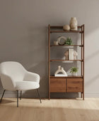 White chair and wooden bookshelf with decorative items in a minimalistic room.