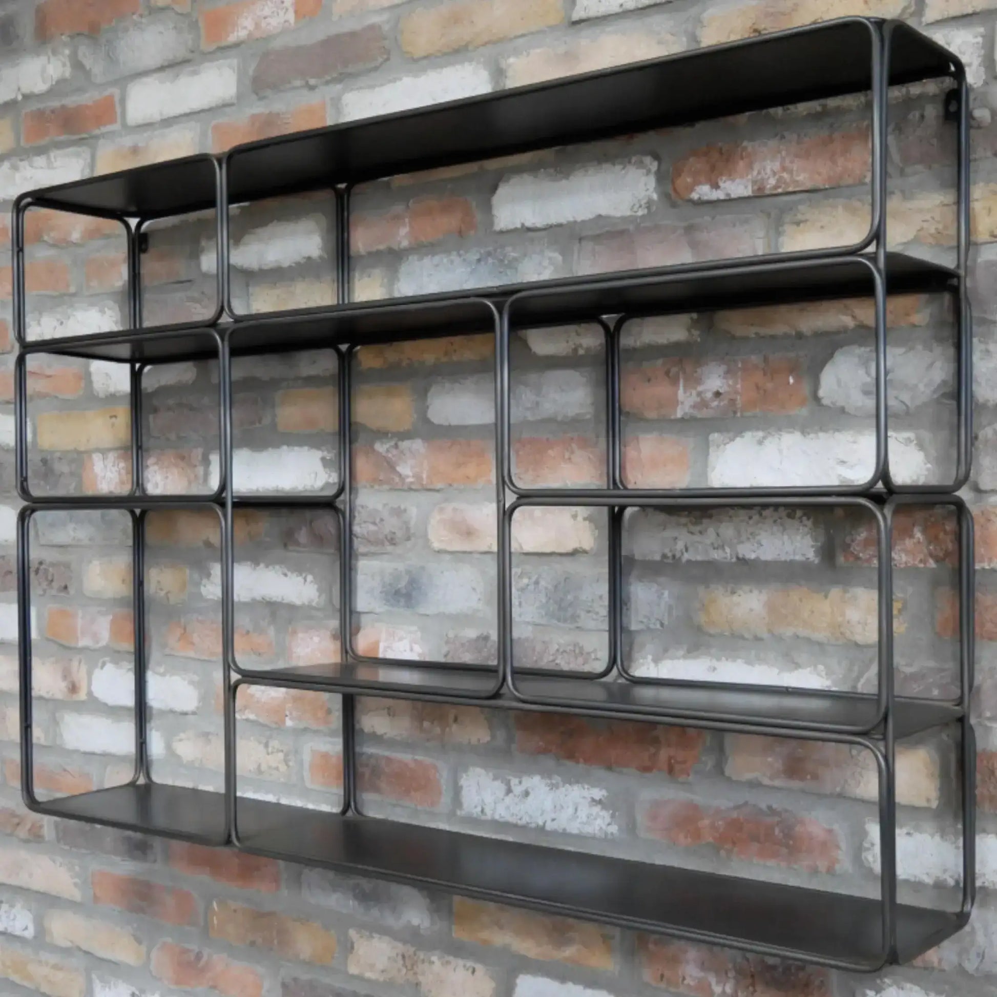 Black metal wall shelf against a brick wall background