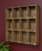 Wooden wall-mounted shelf with multiple compartments against a red wall.