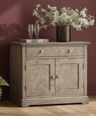 Wooden sideboard with decorative items against a maroon wall