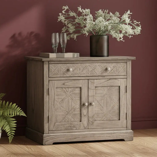 Wooden sideboard with decorative items against a maroon wall